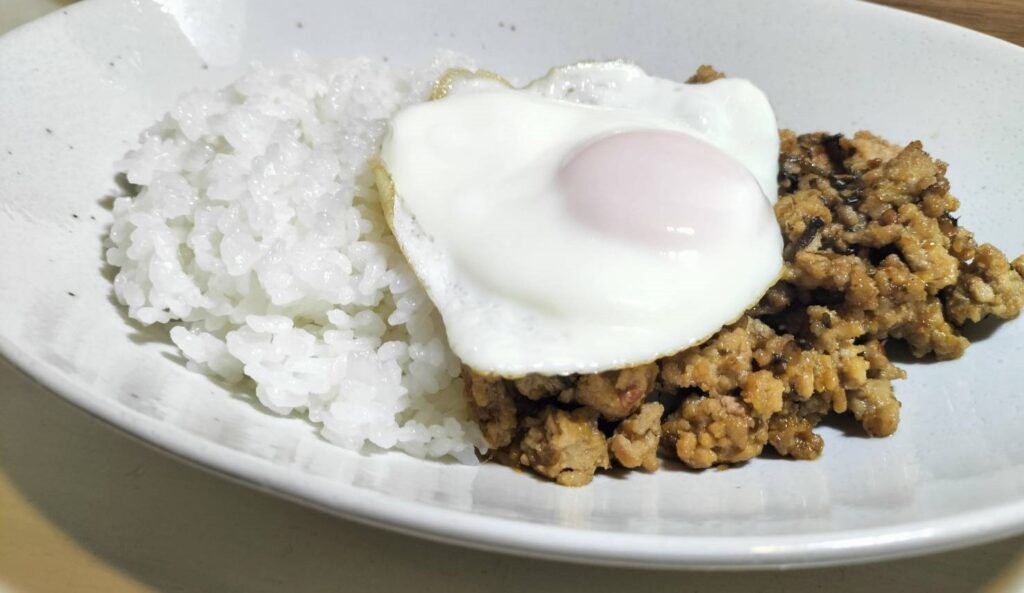 味付けされたひき肉とご飯が盛り付けられており、上には目玉焼きが乗ったガパオライス